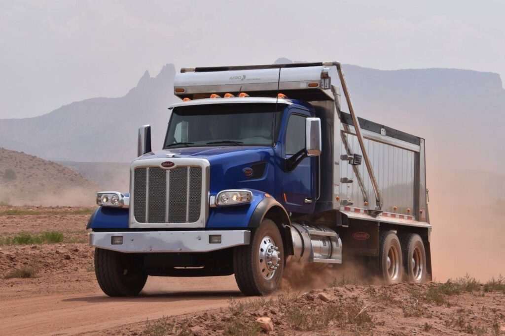 Online Dump Truck Marketplace - Blue dump truck on dirt road