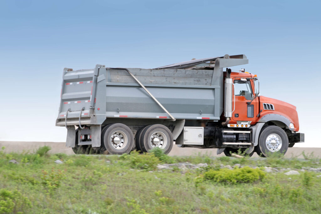 Types of Dump Truck - Side view of a dump truck travelling  a highway on its way to a construction site.