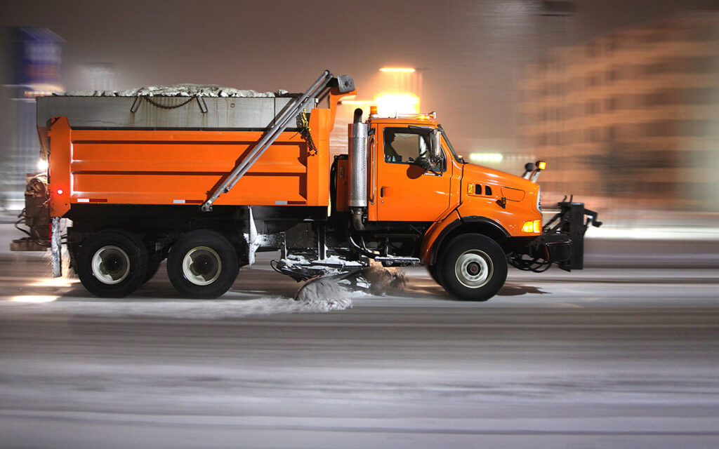 DumpTruckN - Working to become the #1 resource for dump truck owners - Orange dump truck plowing snow on highway