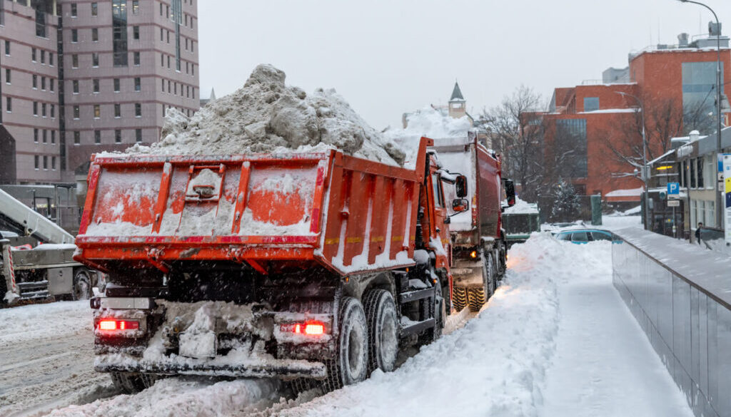Weather impact on dump trucks - Dump trucks loaded with snow driving on a snowy road