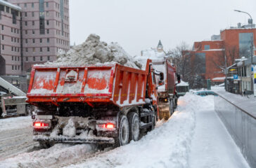 Weather impact on dump trucks - Dump trucks loaded with snow driving on a snowy road