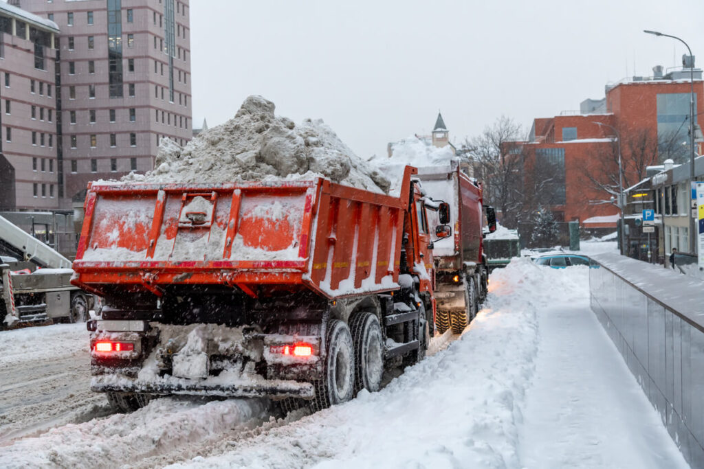 Weather impact dump truck - How weather conditions affect dump truck operations - Dump trucks hauling snow on a snowy road