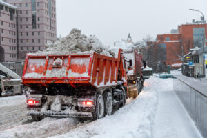 Weather impact on dump trucks - Dump trucks loaded with snow driving on a snowy road