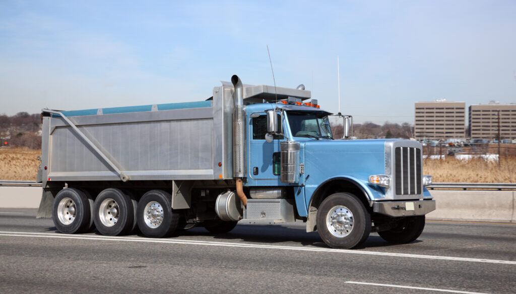 Blue Dump Truck on the Highway - Understanding Dump Truck Terminology: A Beginner’s Guide
