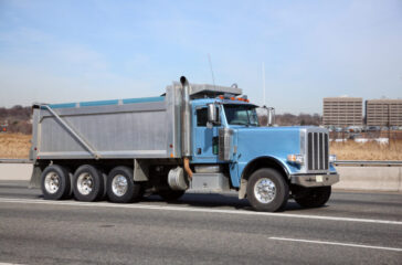 Blue Dump Truck on the Highway - Understanding Dump Truck Terminology: A Beginner’s Guide