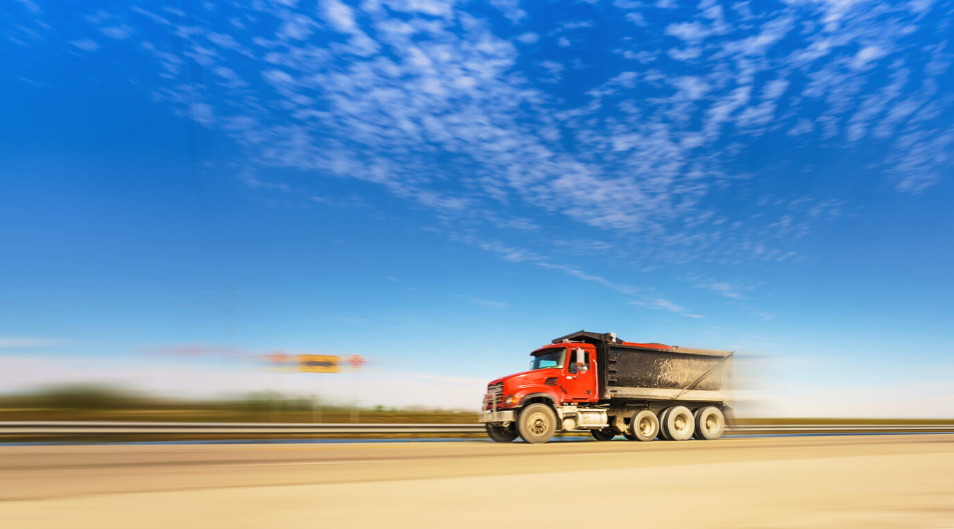 Marketing strategies to grow your dump truck business - Red dump truck on highway.