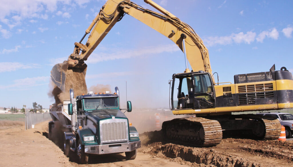 Dump truck market growth - dump truck being loaded by excavator