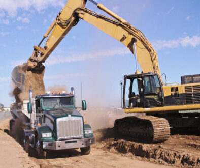 Dump truck market growth - dump truck being loaded by excavator