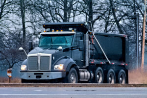 Black dump truck driving on a road