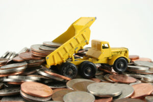Toy truck on a pile of coins How Can You Lower Your Payment