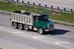 Green dump truck on highway dump truck payment