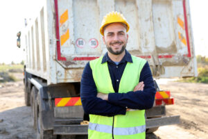 Smiling worker in safety gear. hiring dump truck drivers