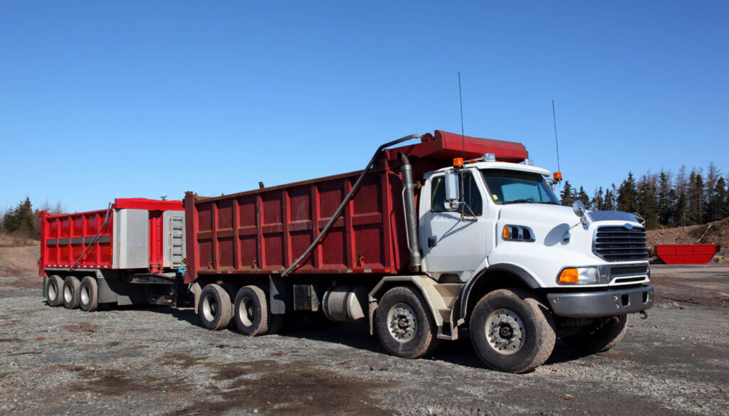White dump truck on gravel site- How to Buy a Dump Truck