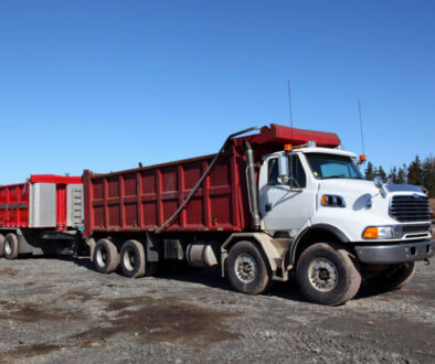 White dump truck on gravel site- How to Buy a Dump Truck