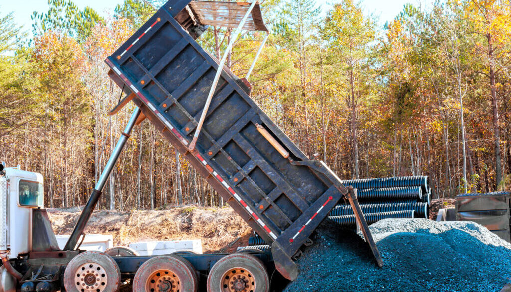 Dump truck unloading gravel on site