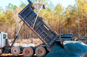 Dump truck unloading gravel on site