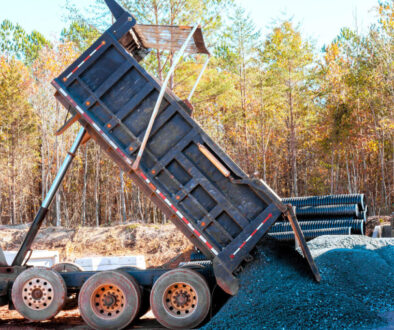 Dump truck unloading gravel on site