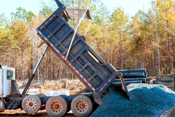 Dump truck unloading gravel on site